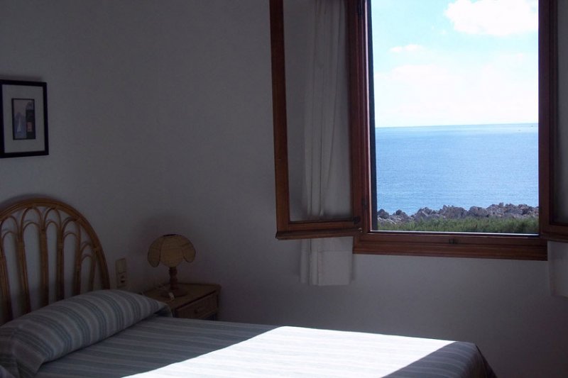 Habitación con cama individual y buenas vistas al mar de Menorca.